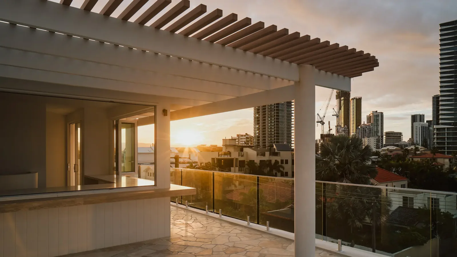 A white pergola over a terrace at sunset